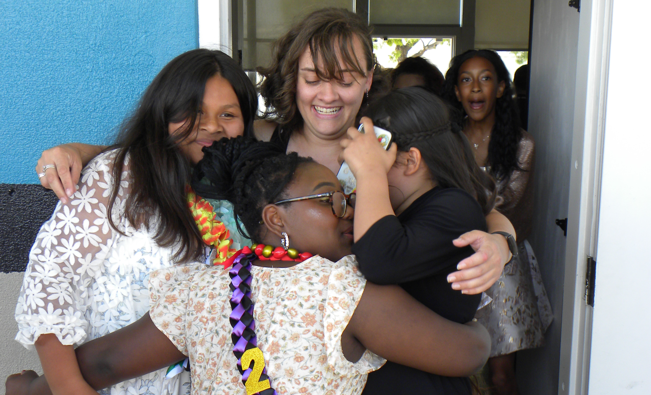 students hugging teacher
